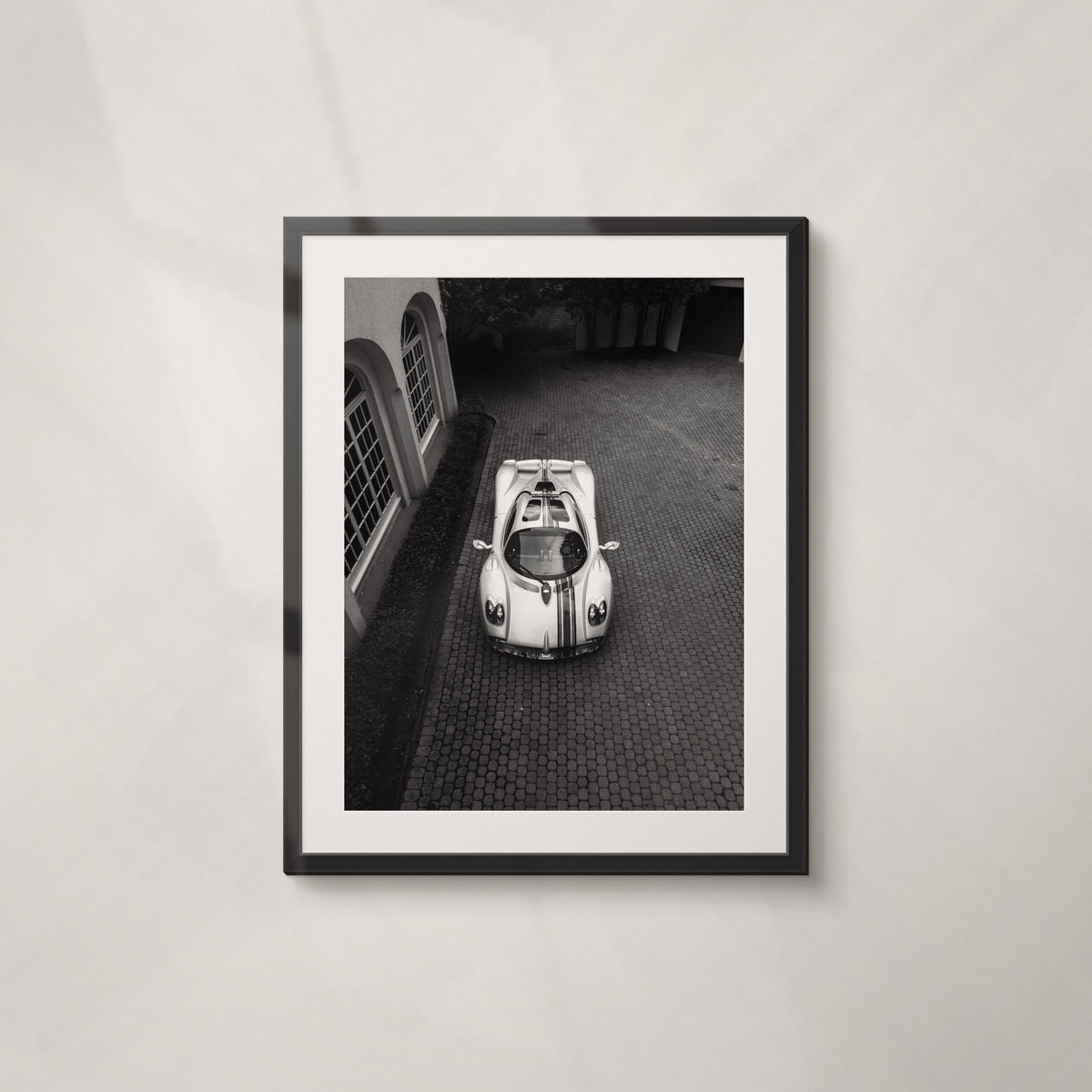Paddock: framed black and white aerial print of a Pagani in a cobbled courtyard